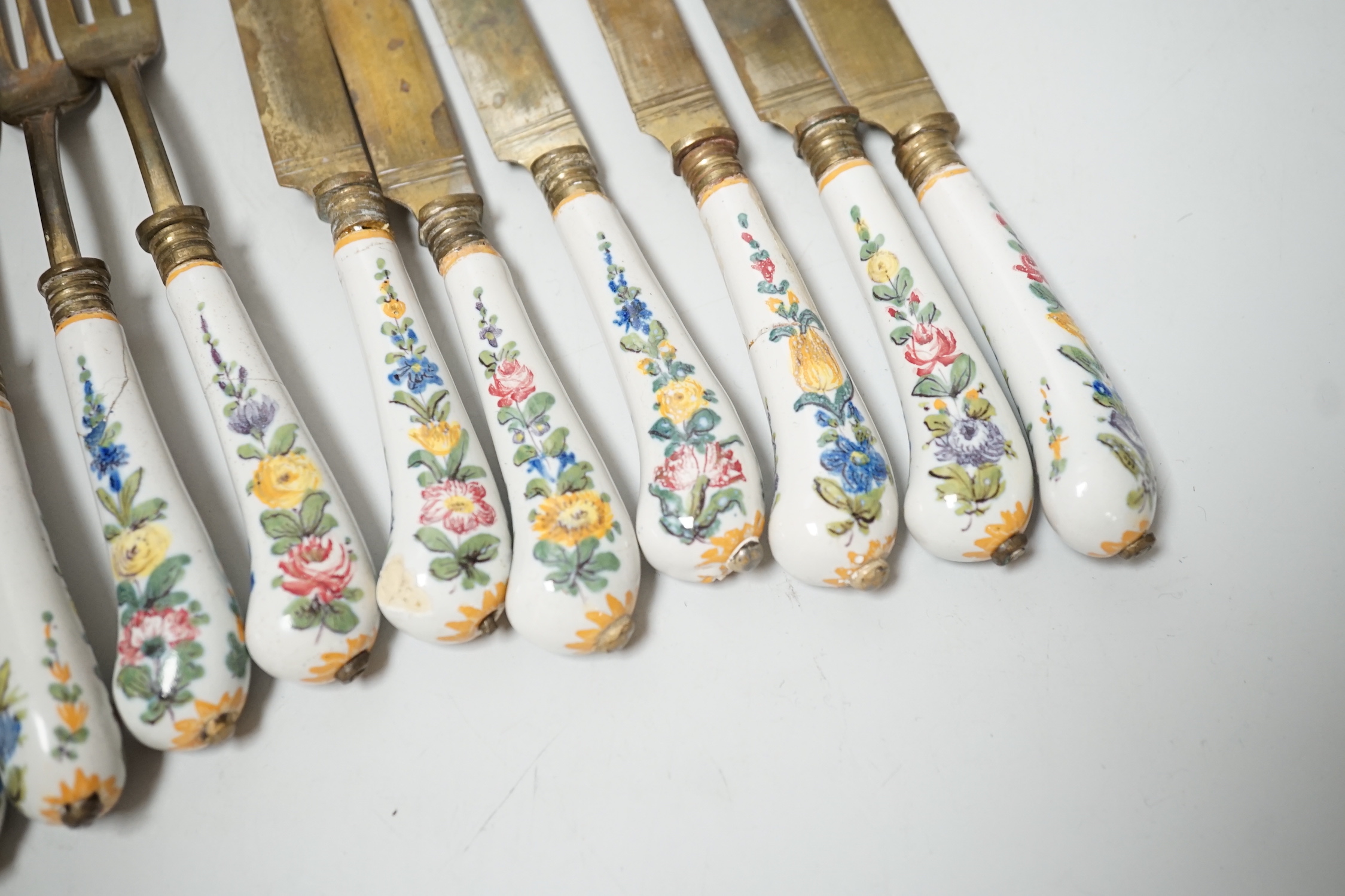 Six pairs of French Faience pistol grip handled knives and forks